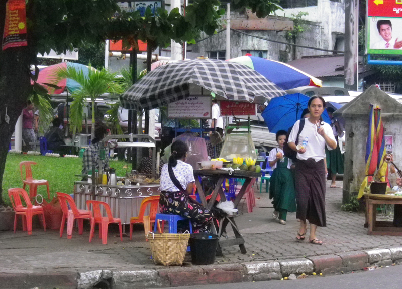 カメラを向けたらピースサインで応じた ロンジー（ミャンマーの民族衣装）姿のミャンマー人男性。ヤンゴンで